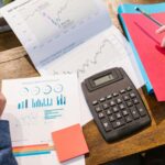 Financial analysis and planning tools with graphs and calculator on a table.